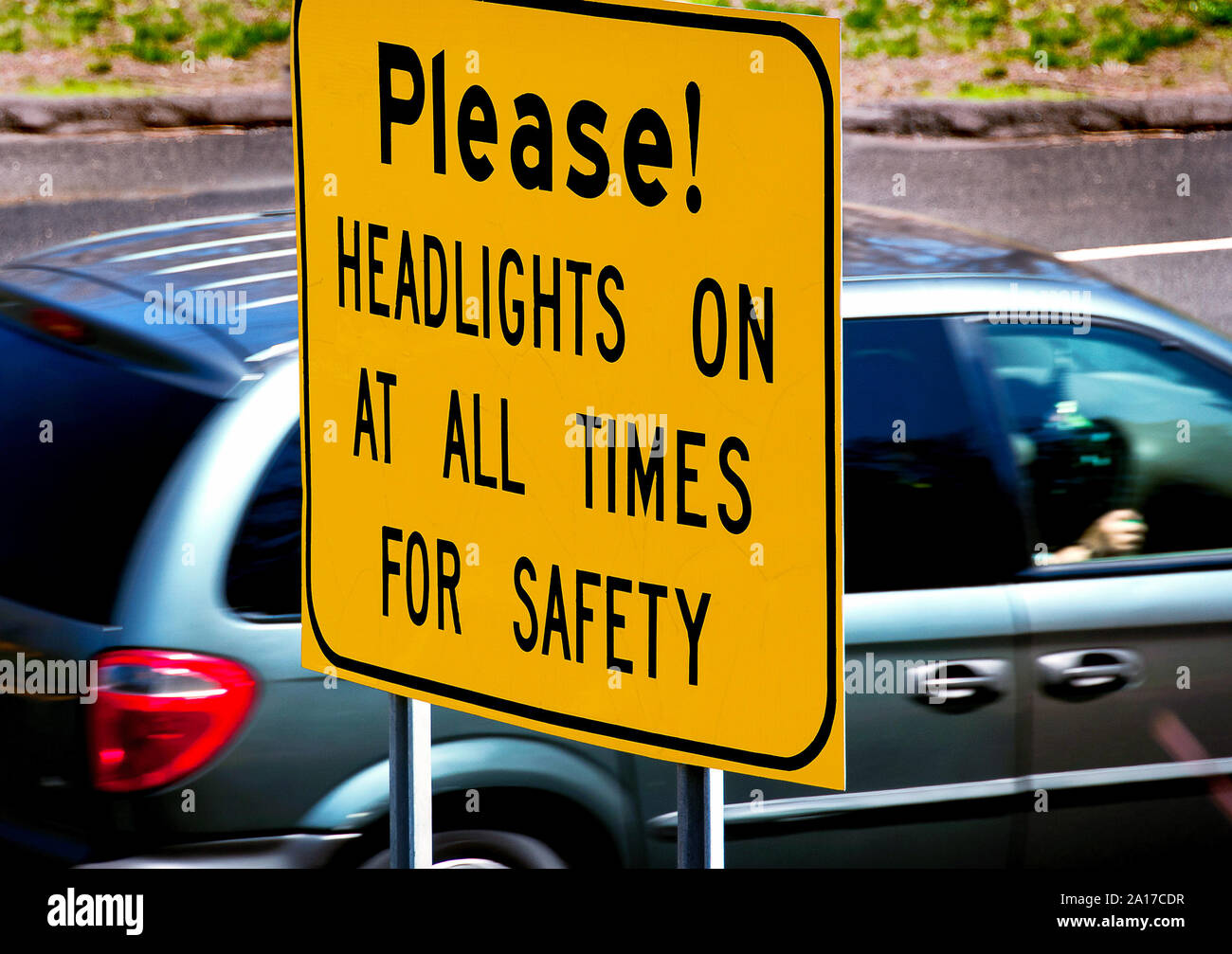 Dangerous road warning sign requires headlights on for safety Stock Photo