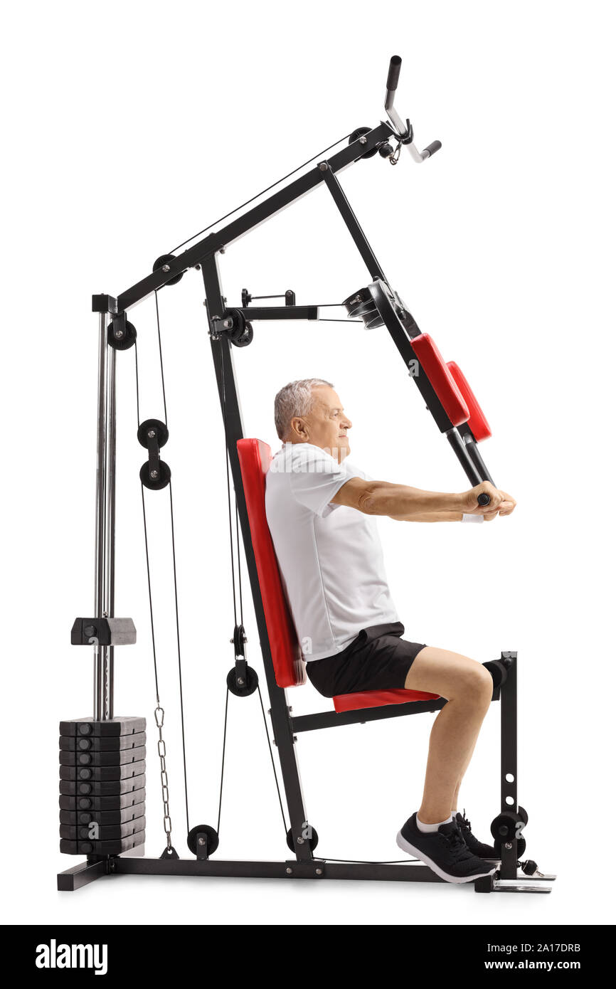 Full length profile shot of a senior man sitting on a fitness machine ...
