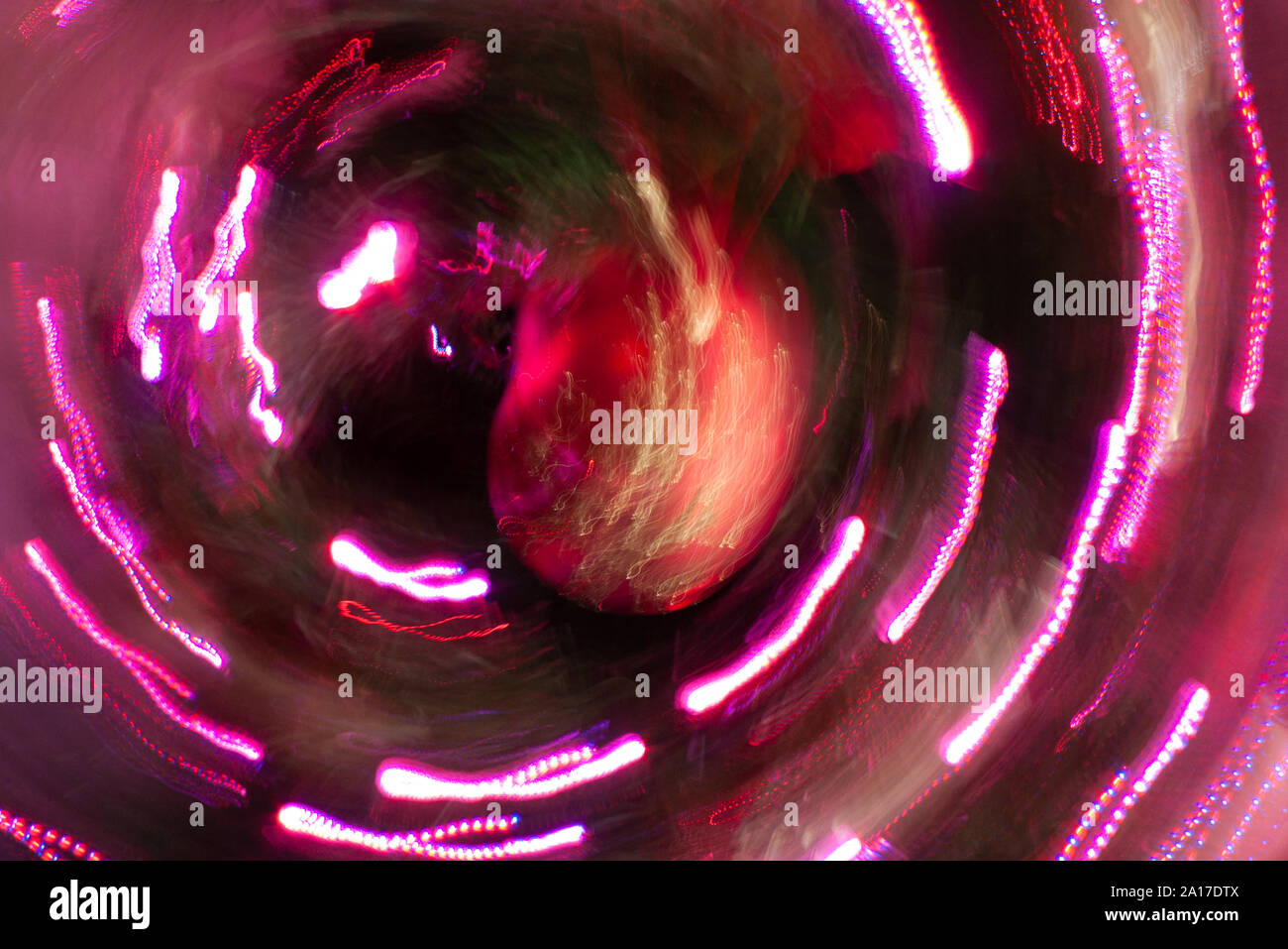 Intentional camera movement with red fairy lights around a Christmas bauble Stock Photo