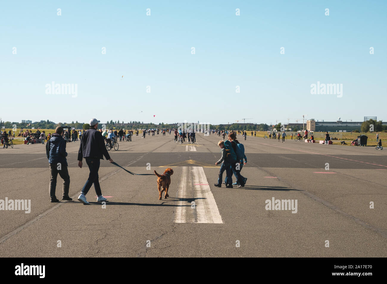 Berlin, Germany - September 2019: Many People walking with dog on street or Airfield (Flughafen Tempelhof), former city airport in Berlin Stock Photo