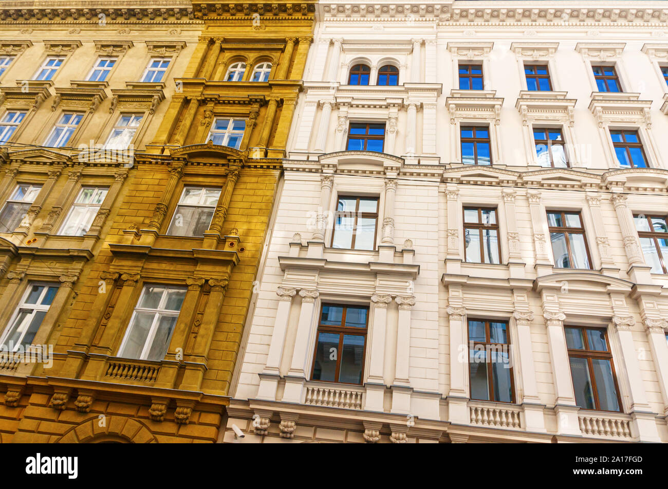 Monumental white and yellow ochre colored facade in neoclassical architectural style with ornamented windows. Budapest, Hungary. Stock Photo