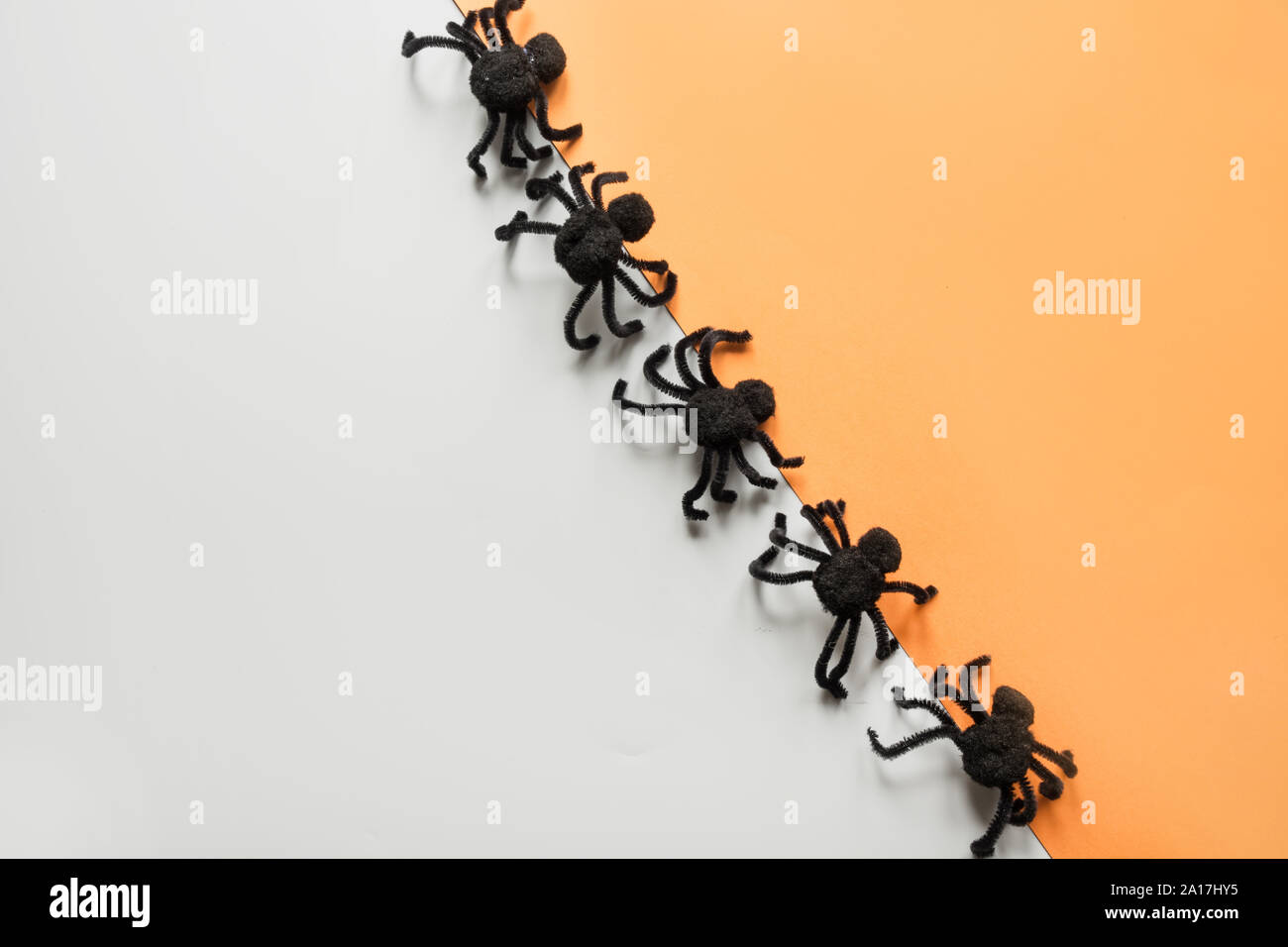 Halloween decorations with black spiders on orange and grey background ...