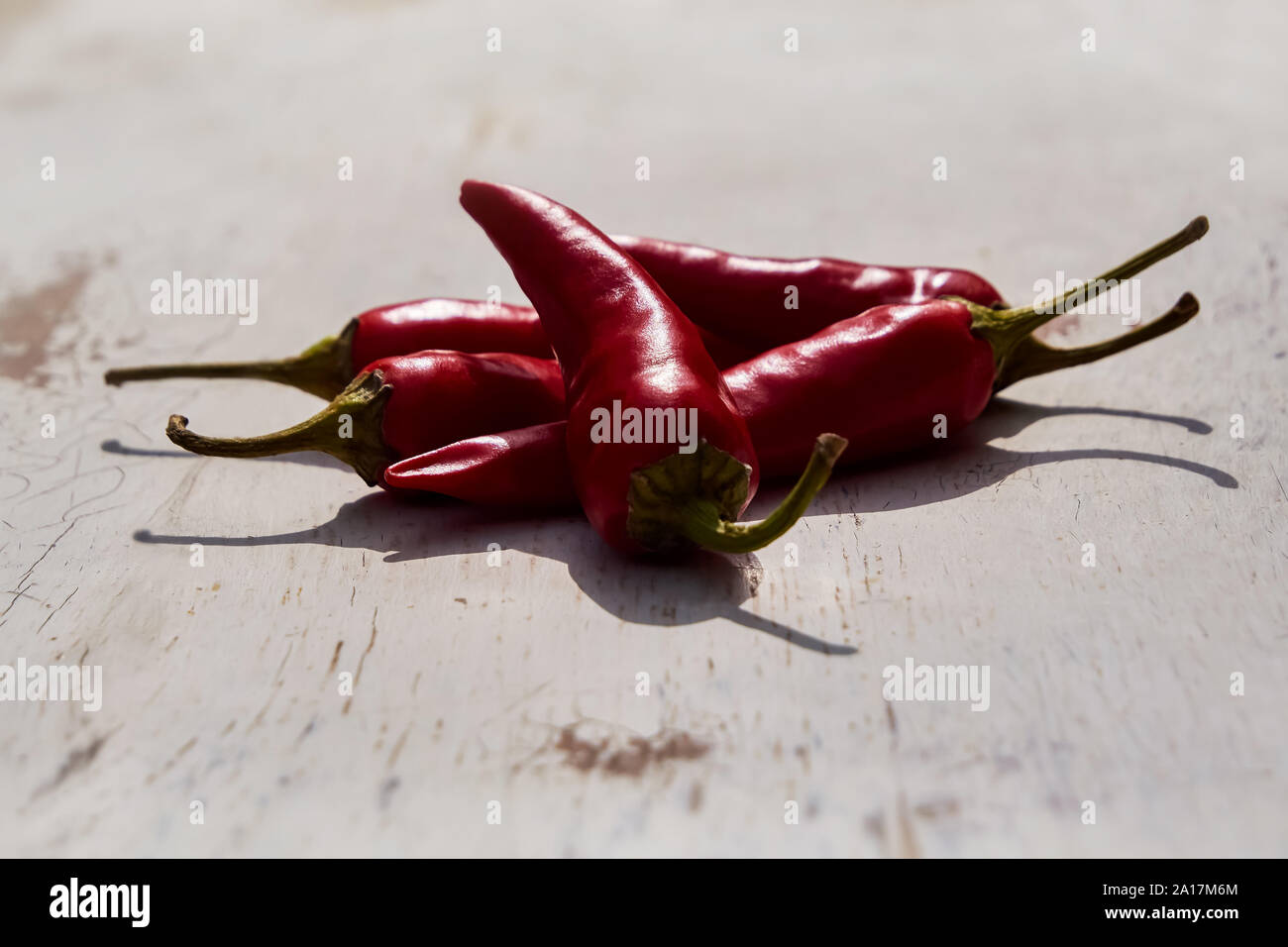 Fresh red chili peppers on an old vintage wooden table, copy space, soft selective focus Stock Photo