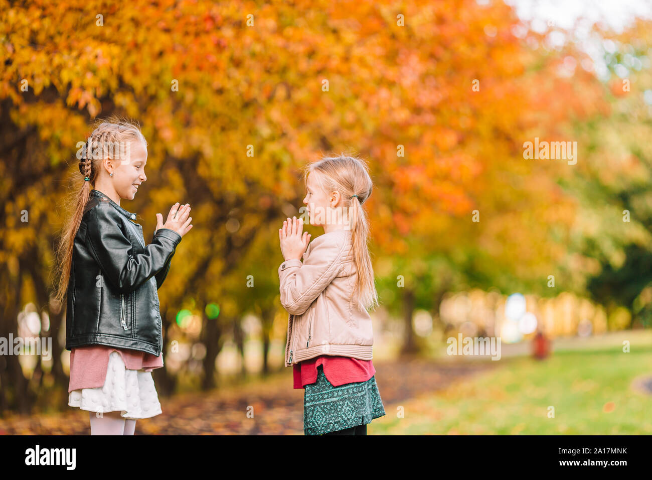 Two little girls playing in the park in autumn day Stock Photo - Alamy