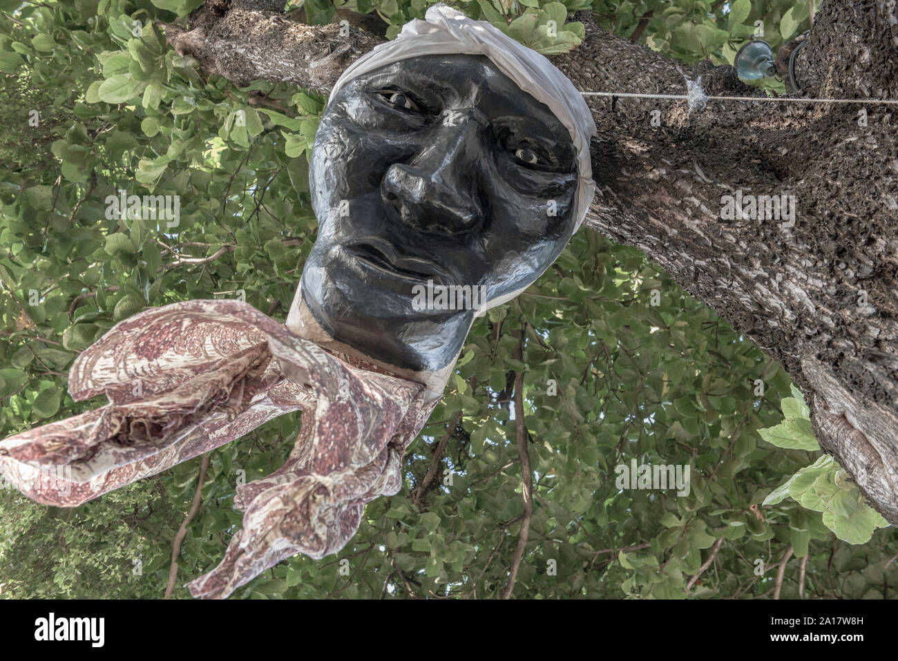 Hanging head sculpture on tree Stock Photo