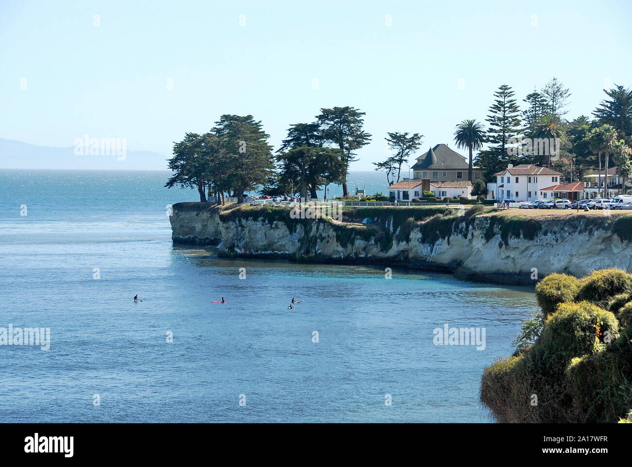 Surfers below West Cliff Drive with its houses and cliff above Cowell Beach in the City of Santa Cruz on Monterey Bay, California Stock Photo
