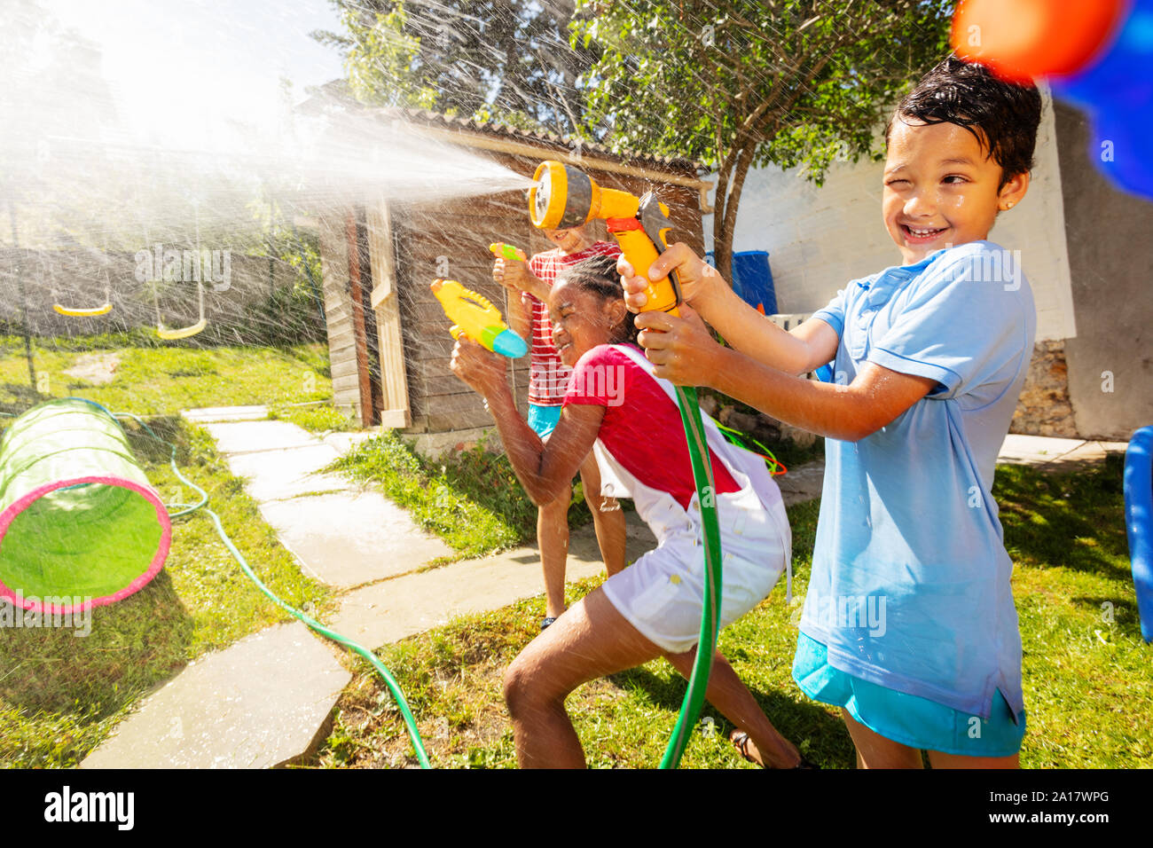 Fun active game of water gun fight with boy showing grimace strong