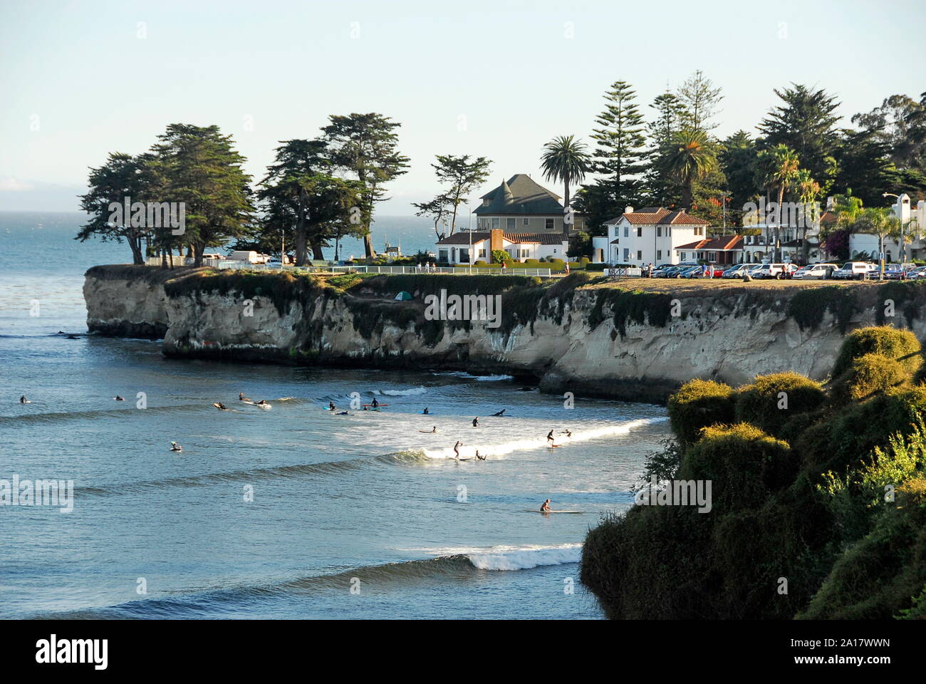 Surfers below West Cliff Drive with its houses and cliff above Cowell Beach in the City of Santa Cruz on Monterey Bay, California Stock Photo
