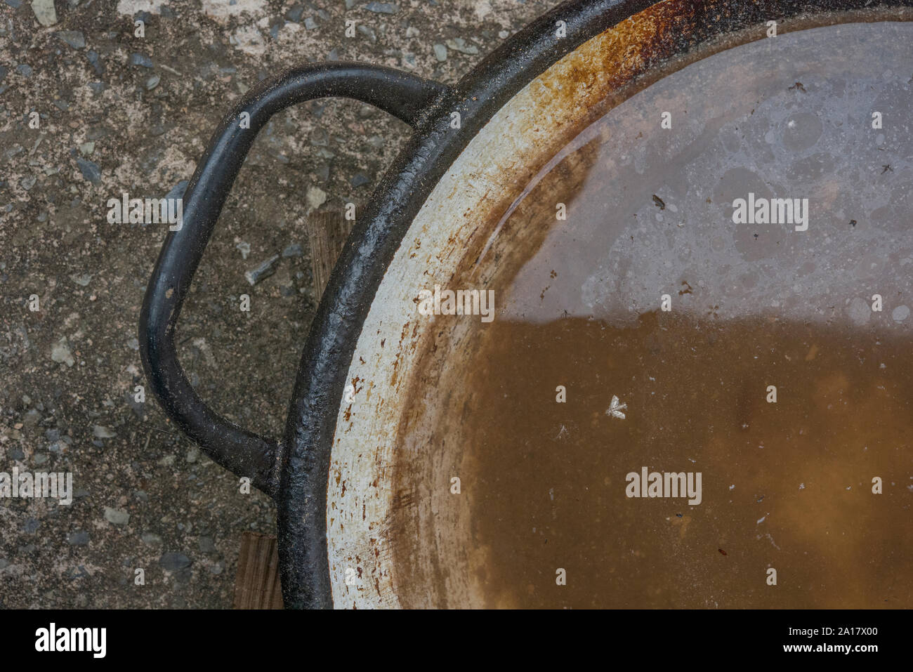 Old iron pan full of dirty standing water Stock Photo