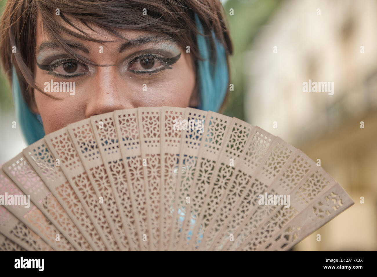 Transgender with colorful make-up waving oriental fan Stock Photo