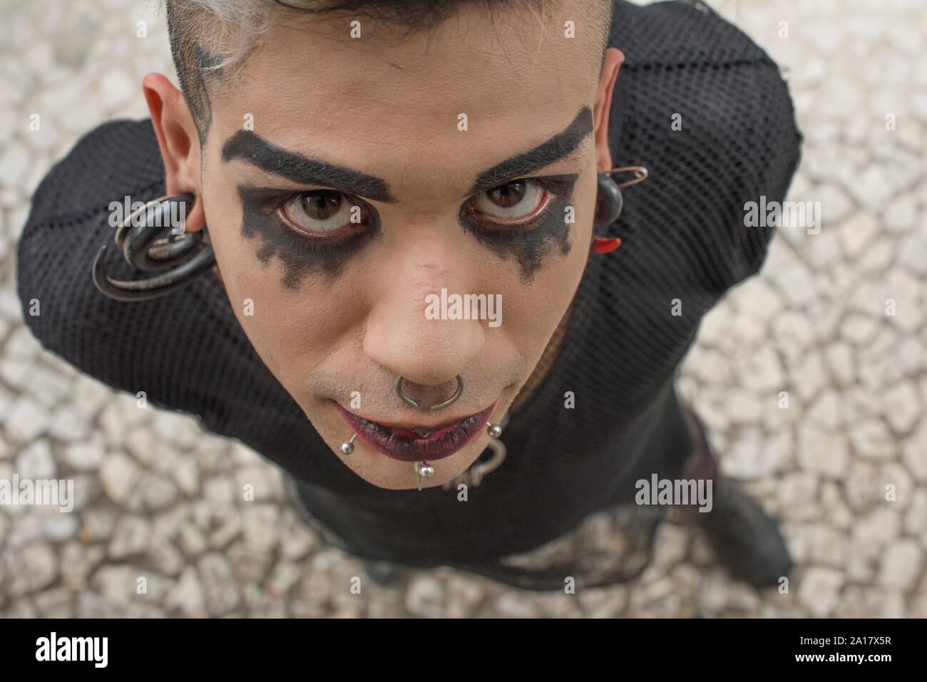 Portrait of alternative guy pierced using red lipstick Stock Photo