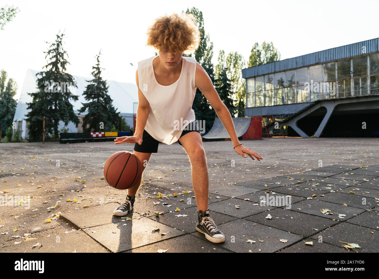 Men with curvy hair play basketball outdoors Stock Photo