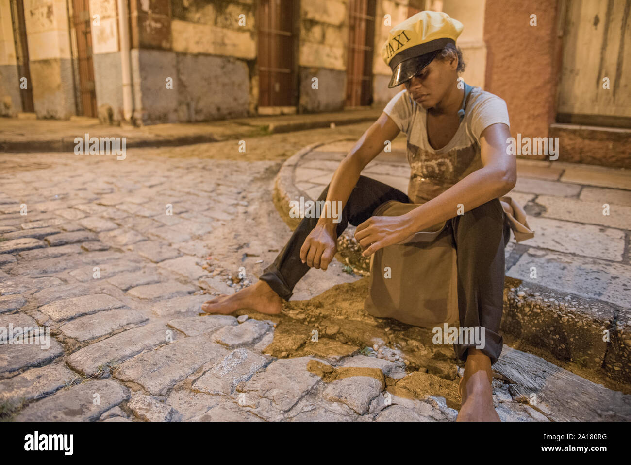 Homeless woman wearing a taxi cap in the streets of Sao Luis Stock Photo