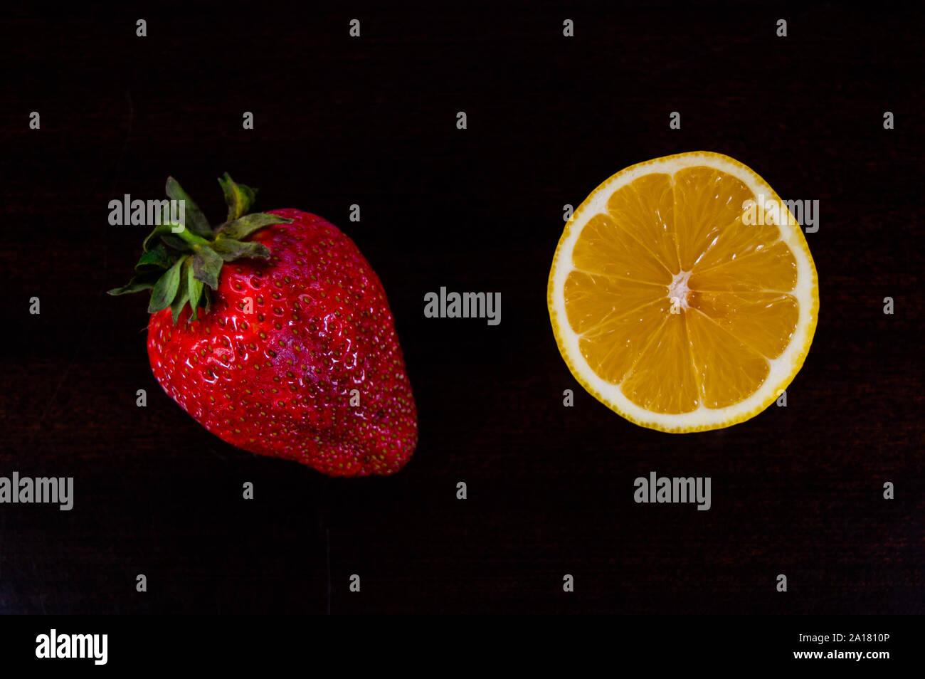 Seasonal fruit strawberry and orange isolated on a black background. Fruits concept. Stock Photo