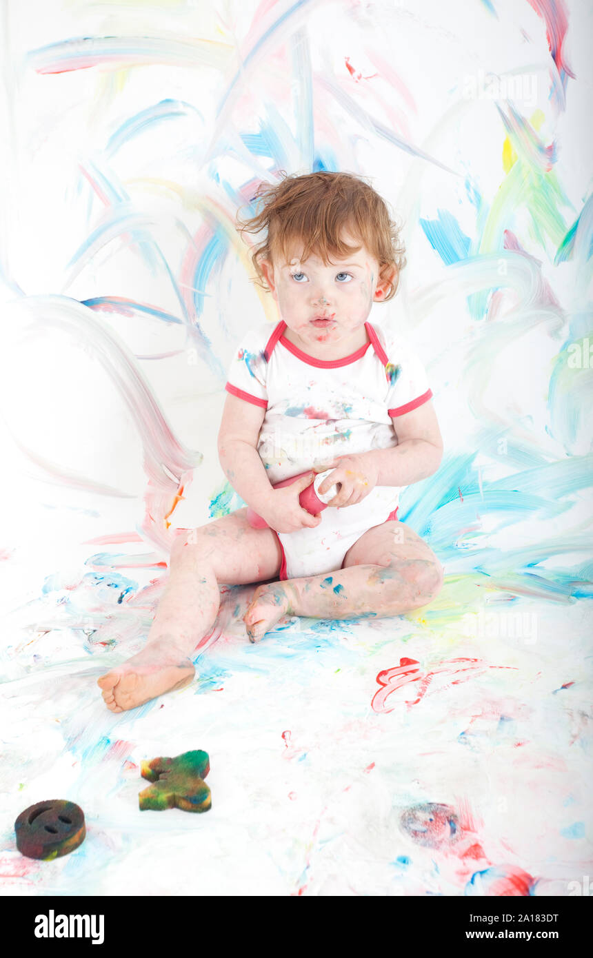 Female toddler sat on floor covered in paint Stock Photo - Alamy