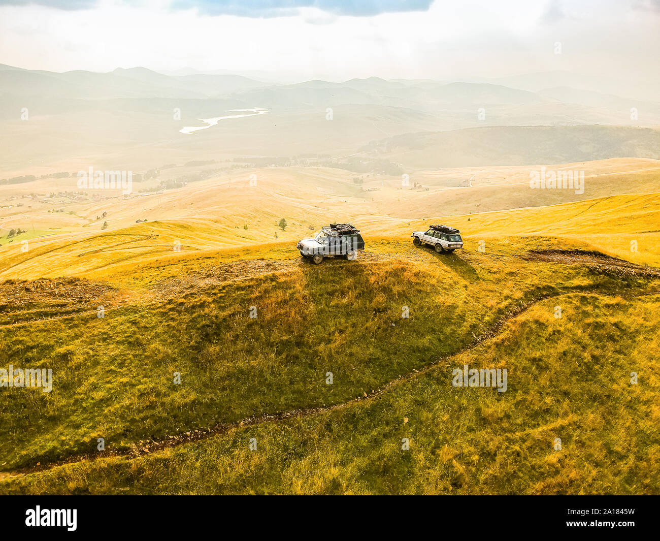 Two off road cars standing in sunset on the top of the Mount Cuker near Zlatibor in Serbia Stock Photo