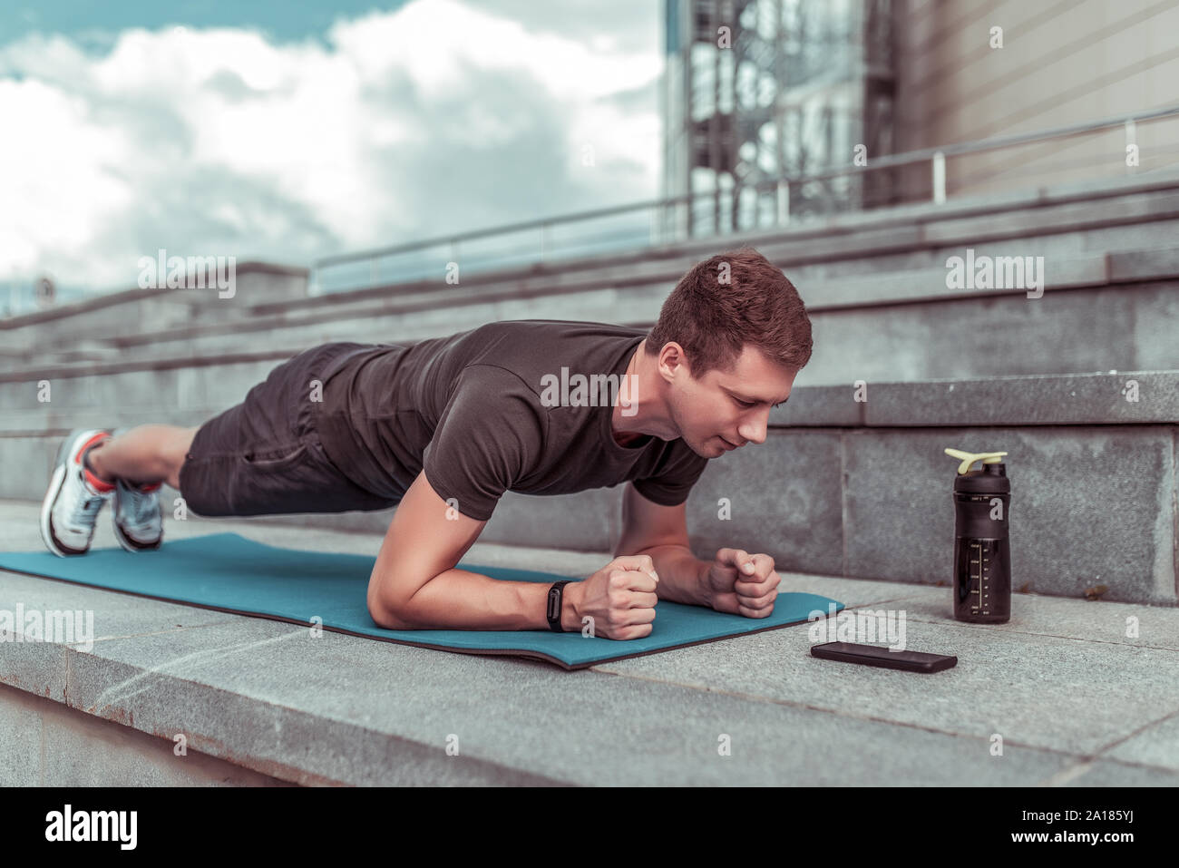 Man In Training Summer City Stands Emphasis Lying Down Plank Abs Training Abdominal Muscles Stretching Flexibility Looks Smartphone Application Stock Photo Alamy