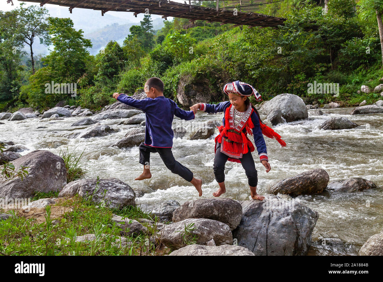 Red Dao ethnic minority boy and girl (Dao Do), playing by a river in Hoang Su Phi, Ha Giang province, in the mountainous northwestern part of Vietnam. Stock Photo