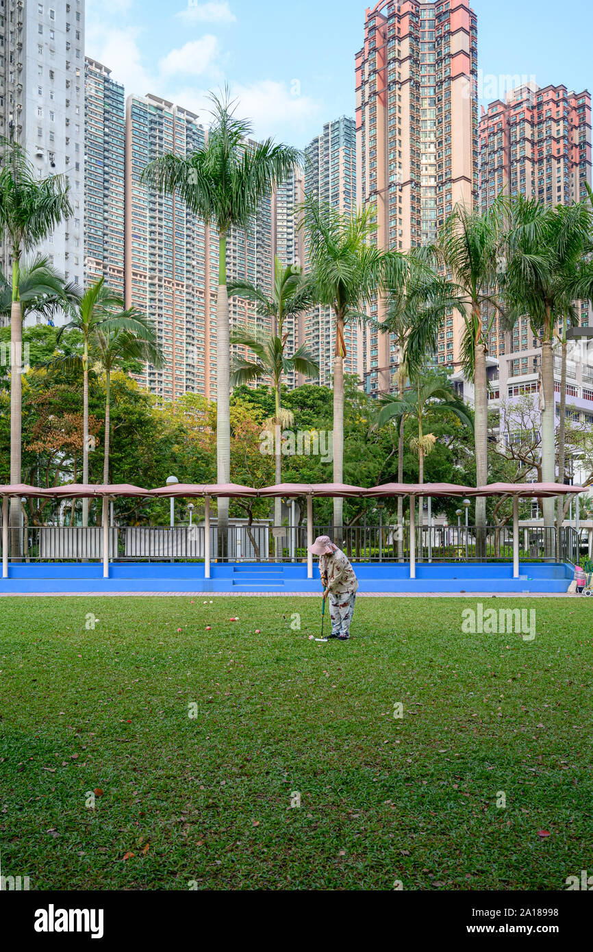 A woman playing croquet at a housing estate in Hung Hom Hong Kong. Stock Photo