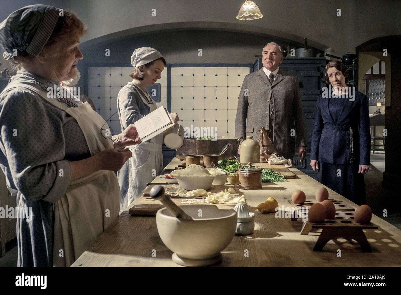 (L to R) Lesley Nicol stars as Mrs. Patmore, Sophie McShera as Daisy, Jim Carter as Mr. Carson and Phyllis Logas as Mrs. Hughes in DOWNTON ABBEY, a Focus Features release. (2019)  Credit: Jaap Buitendijk / Focus Features, LLC / The Hollywood Archive Stock Photo