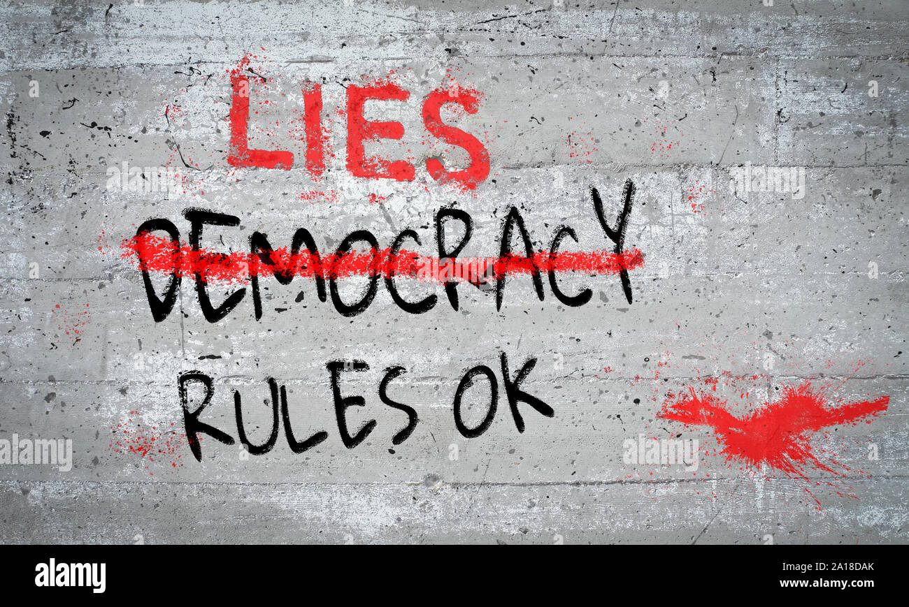 Democracy Rules OK graffiti with democracy text crossed out and replaced by lies on old concrete paint splattered wall. Concept illustration Democracy Stock Photo