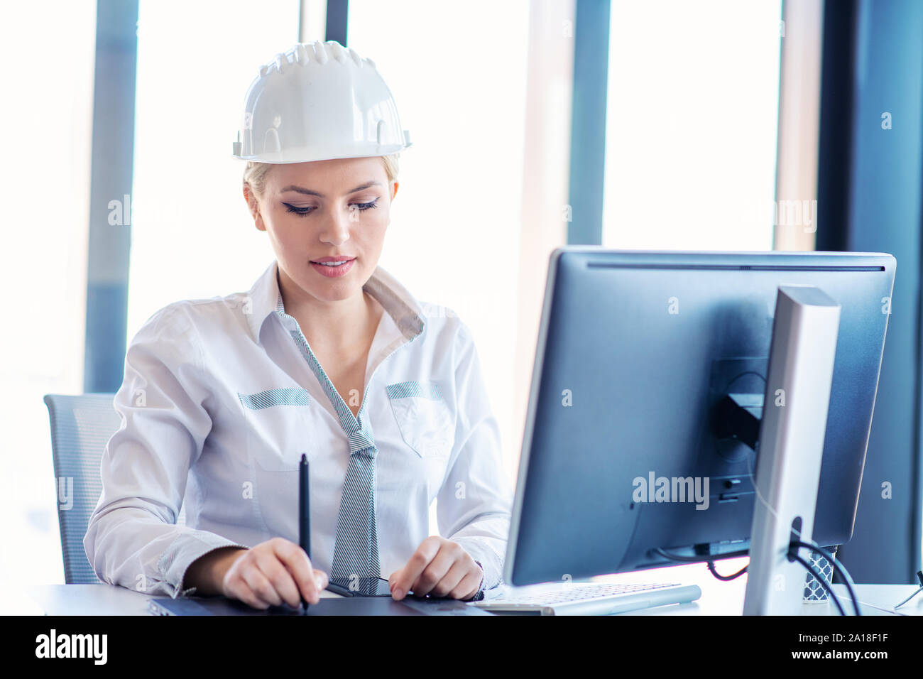 Female designer in office working on architects project Stock Photo