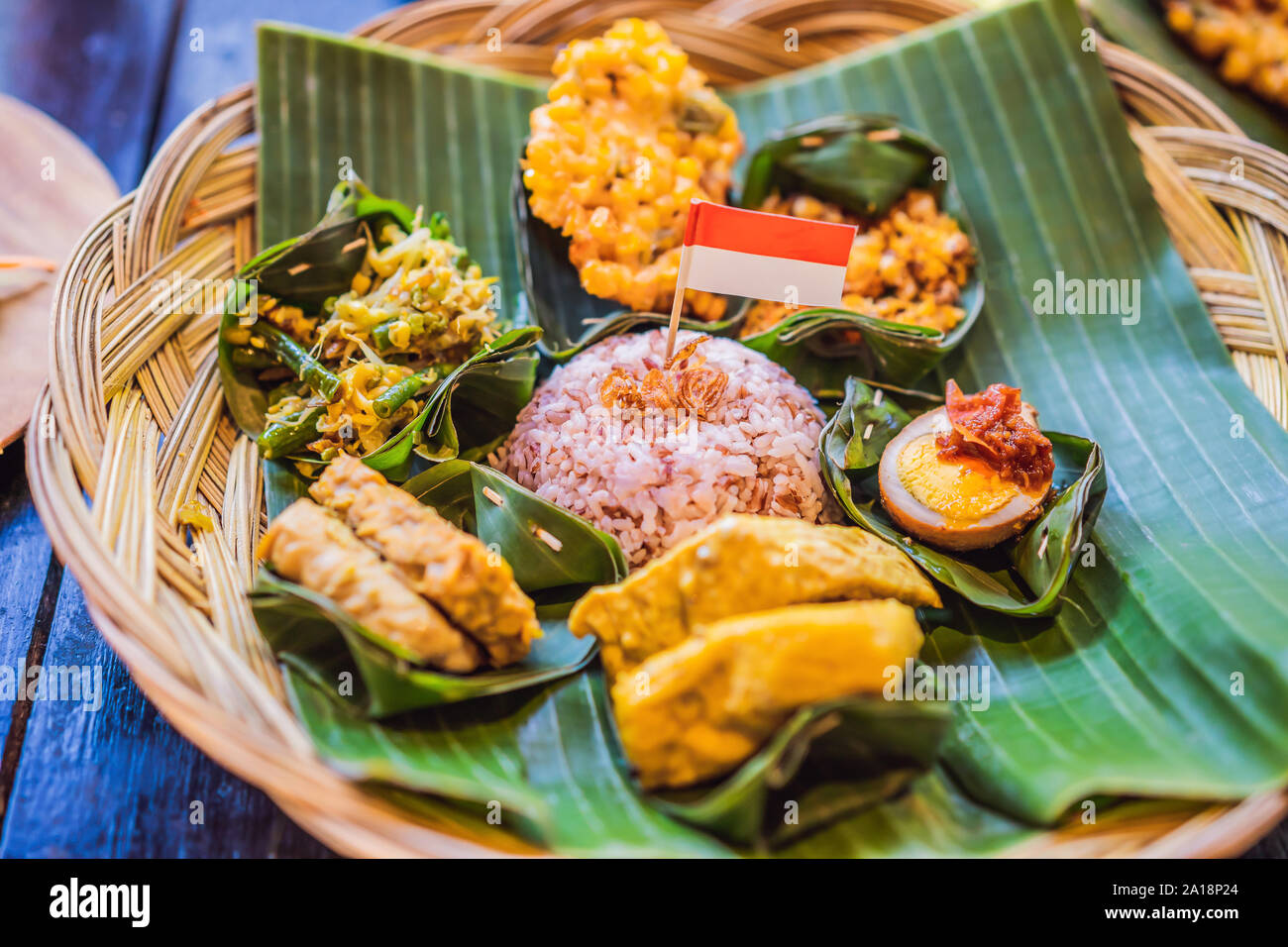 Nasi lemak, Nasi campur, Indonesian Balinese rice with potato fritter, sate lilit, fried tofu, spicy boiled eggs, and peanut Stock Photo
