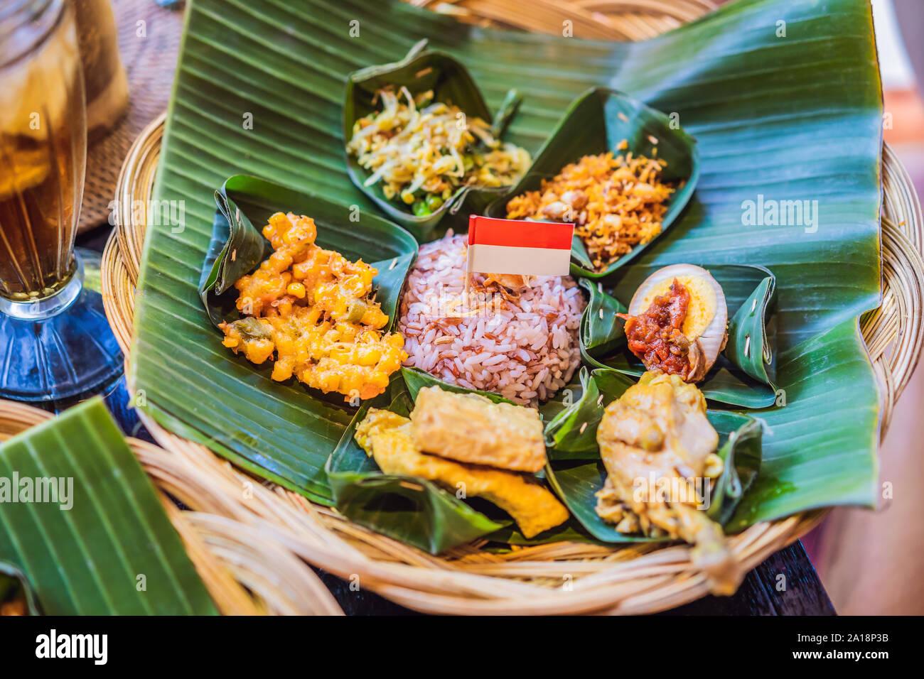 Nasi lemak, Nasi campur, Indonesian Balinese rice with potato fritter, sate lilit, fried tofu, spicy boiled eggs, and peanut Stock Photo