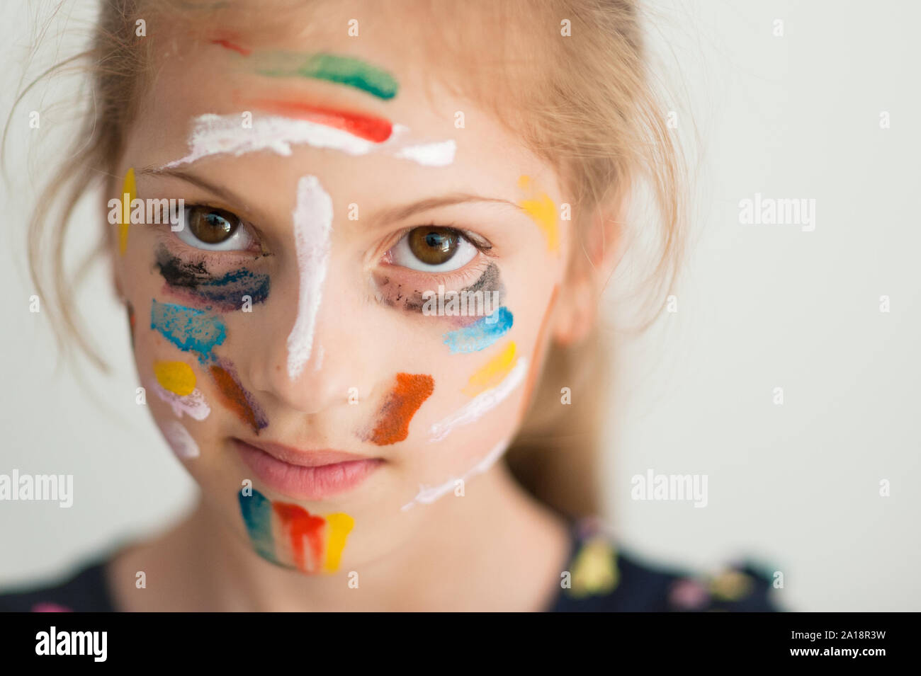 beautiful portrait of little caucasian girl face with colorful painting on her Stock Photo