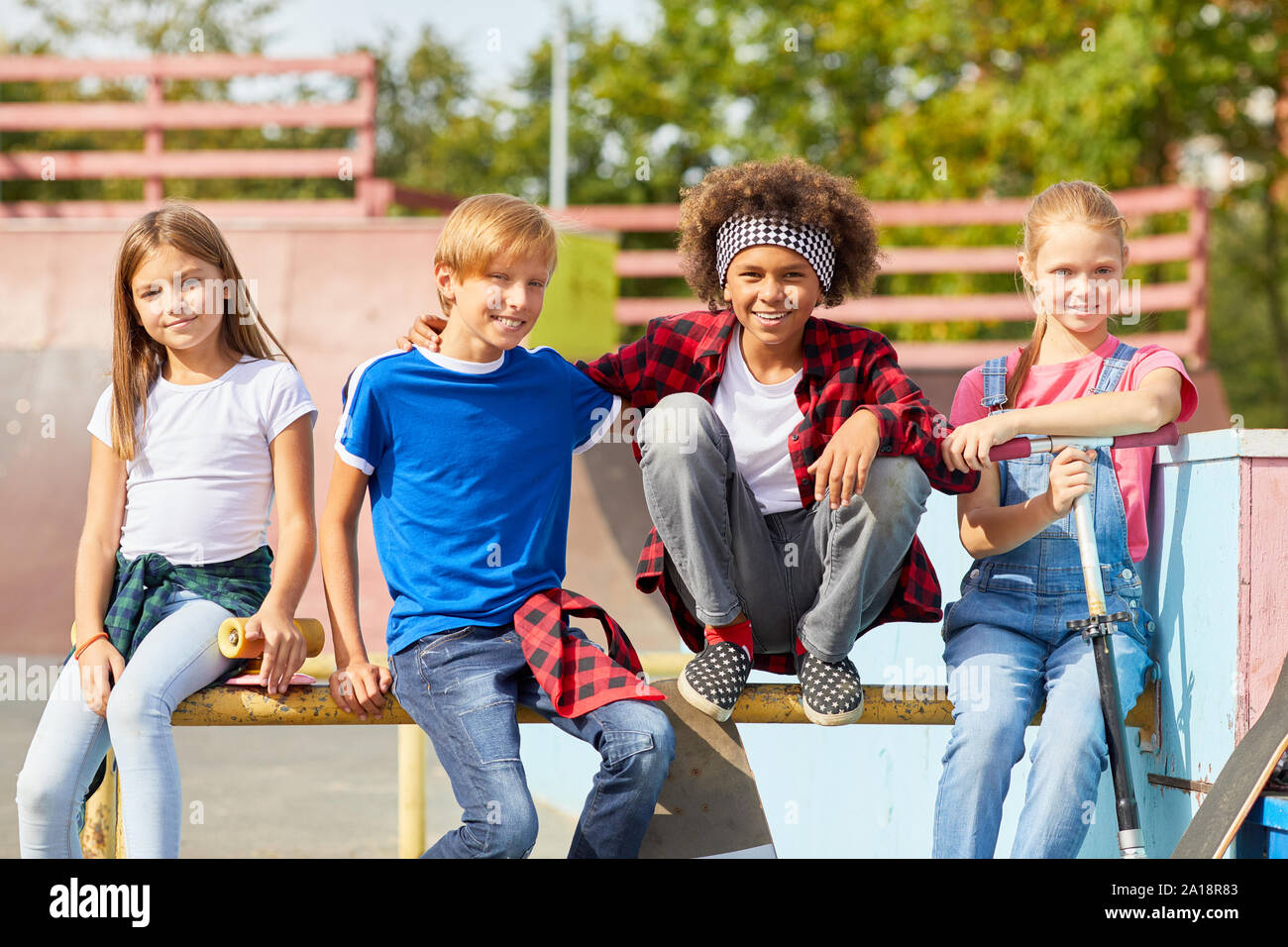 Portrait of multiethnic group of children sitting on the bench and ...