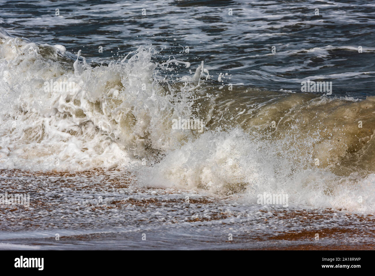 Storm at sea, big foamy waves breaking on shore Stock Photo