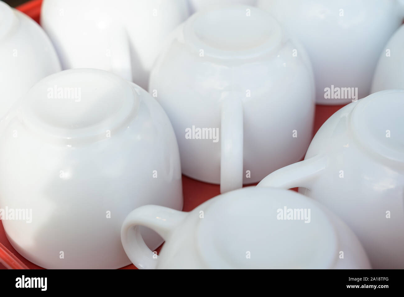 white coffee cups upside down on a red tray, close-up as an abstract ...