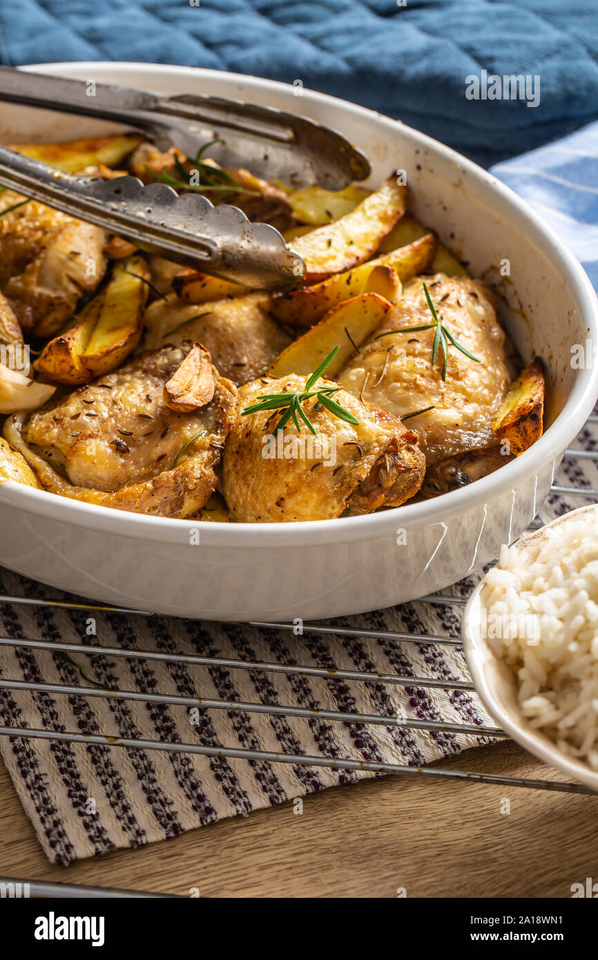 Chicken legs roasted with american potatoes in baking dish Stock Photo