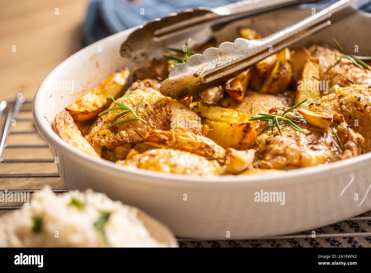 Chicken legs roasted with american potatoes in baking dish Stock Photo