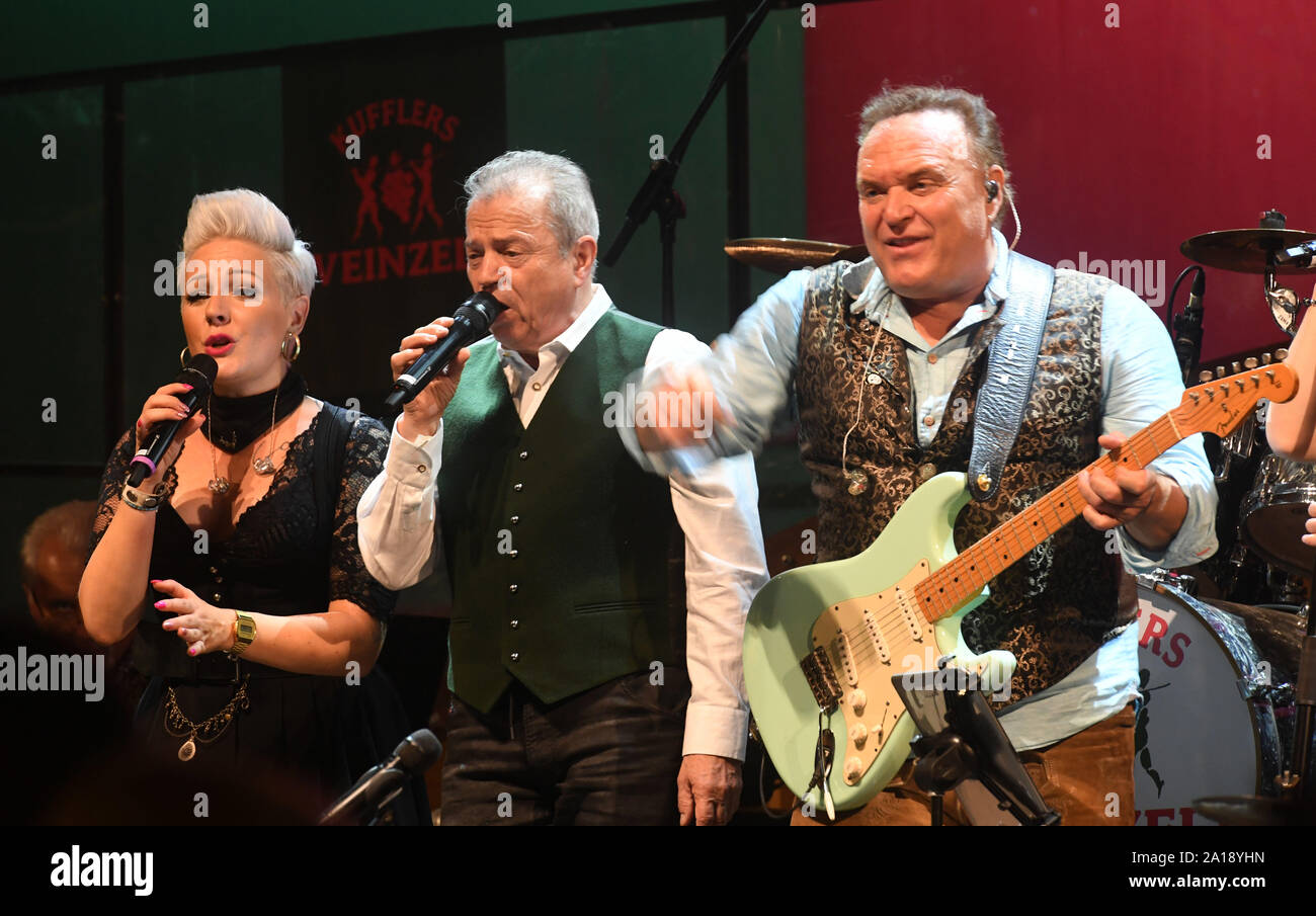 Munich, Germany. 24th Sep, 2019. Oktoberfest 2019, The singer of the 'Spider Murphy Gang' Günther Sigl (2nd from left) sings the song 'Scandal im Sperrbezirk' in the wine tent together with the musicians of the wine tent. The largest folk festival in the world lasts until 6 October. Credit: Felix Hörhager/dpa/Alamy Live News Stock Photo