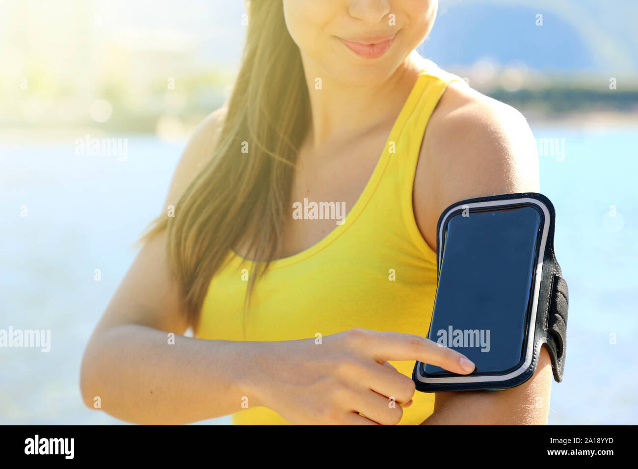 Sport armband for Sporty woman touching her smart phone before outdoor fitness workout at the beach Stock Photo - Alamy