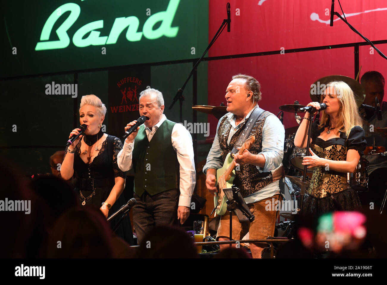 24 September 2019, Bavaria, Munich: Oktoberfest 2019, The singer of the 'Spider Murphy Gang' Günther Sigl (2nd from left) sings the song 'Scandal im Sperrbezirk' in the wine tent together with the musicians of the wine tent. The largest folk festival in the world lasts until 6 October. Photo: Felix Hörhager/dpa Stock Photo
