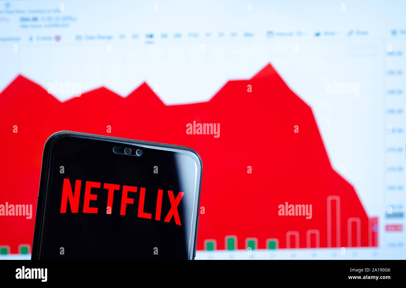 Netflix logo on the smartphone screen and the chart with share (NFLX) price for the last month at the blurred background. Netflix stock falls again. Stock Photo