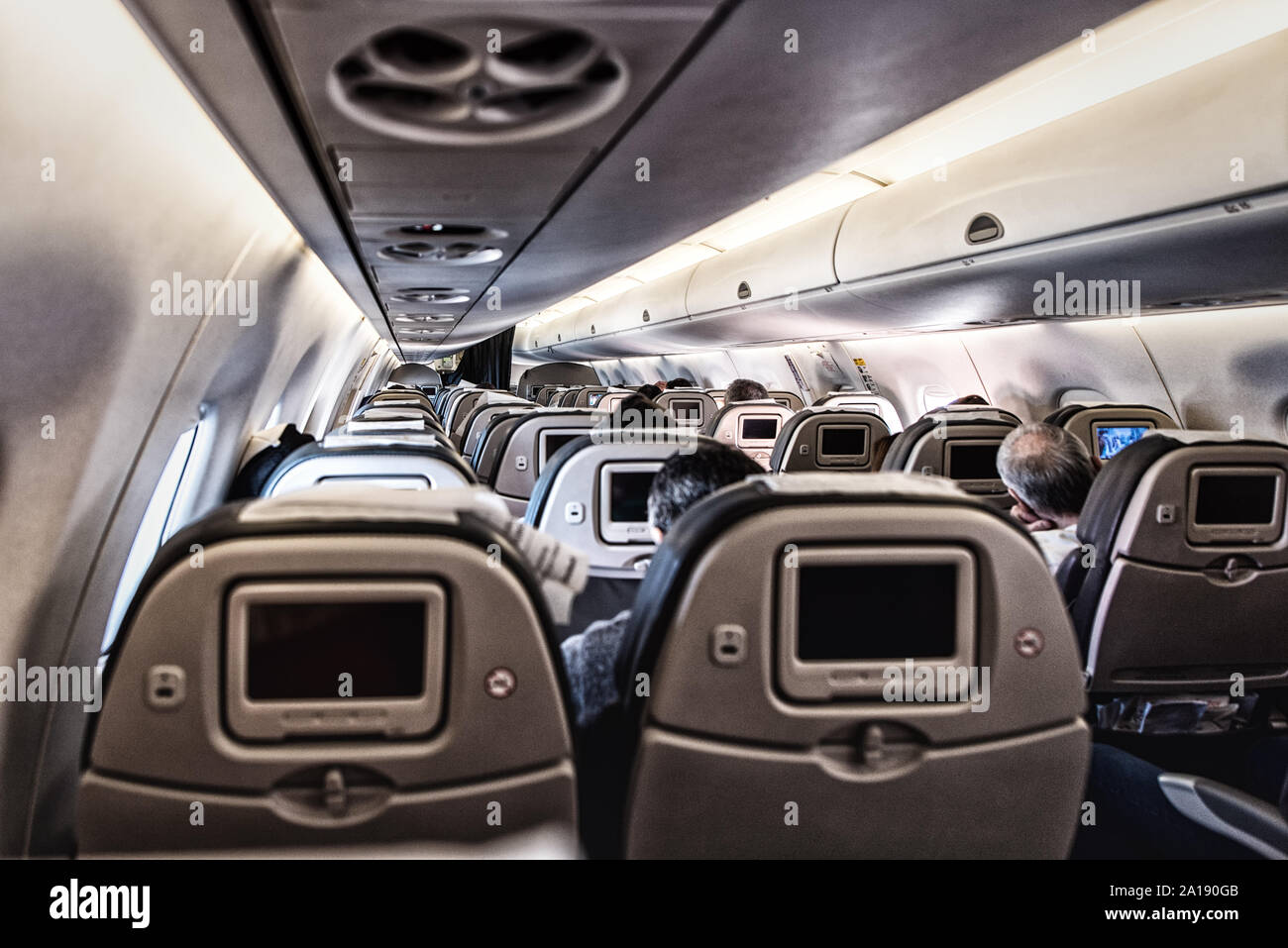 Aircraft cabin, seats with screens. Stock Photo