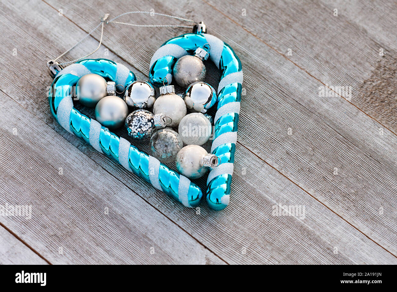 Christmas blue candy cane and silver balls collected on wooden table with copy space on the right, winter holiday concept - Image Stock Photo