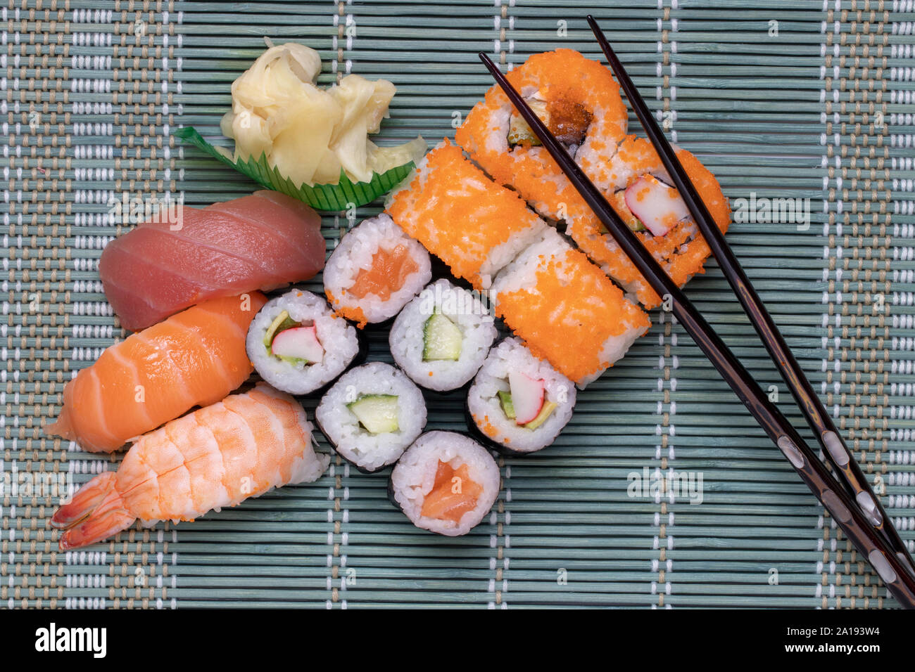 Traditional japanese sushi menu. Close-up of various kinds of sushi rolls  with salmon, sashimi and other slices of raw fish and a pair of wooden  chops Stock Photo - Alamy