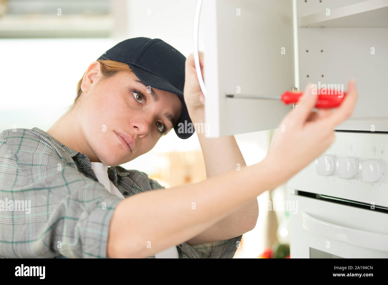 woman using a screw driver while installing a Stock Photo Alamy