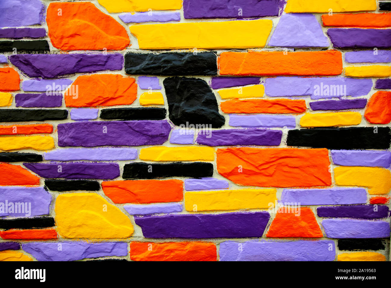 Multicolor violet and orange  brick wall close up Stock Photo