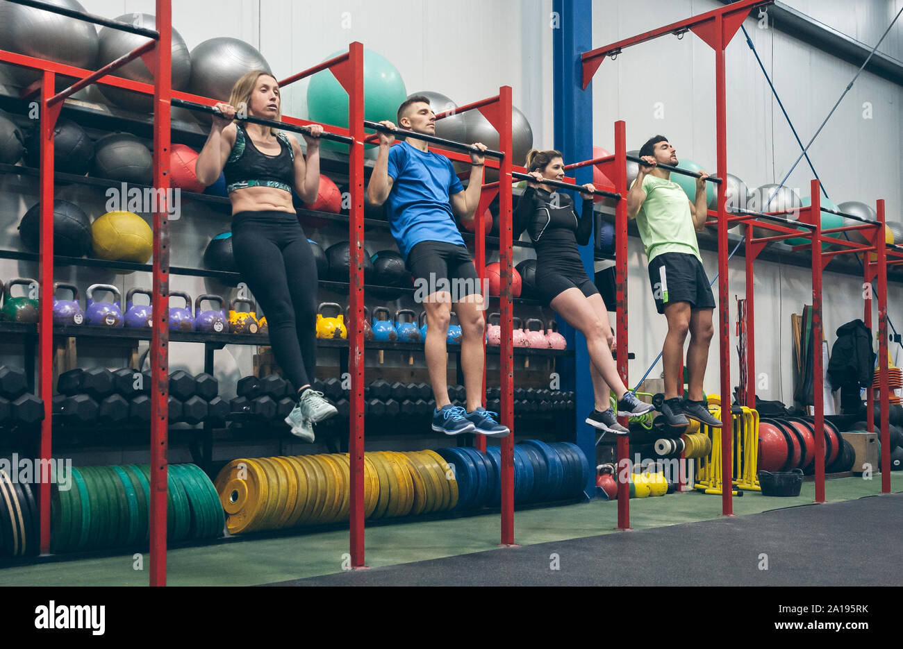 Athletes doing pull ups in the gym Stock Photo