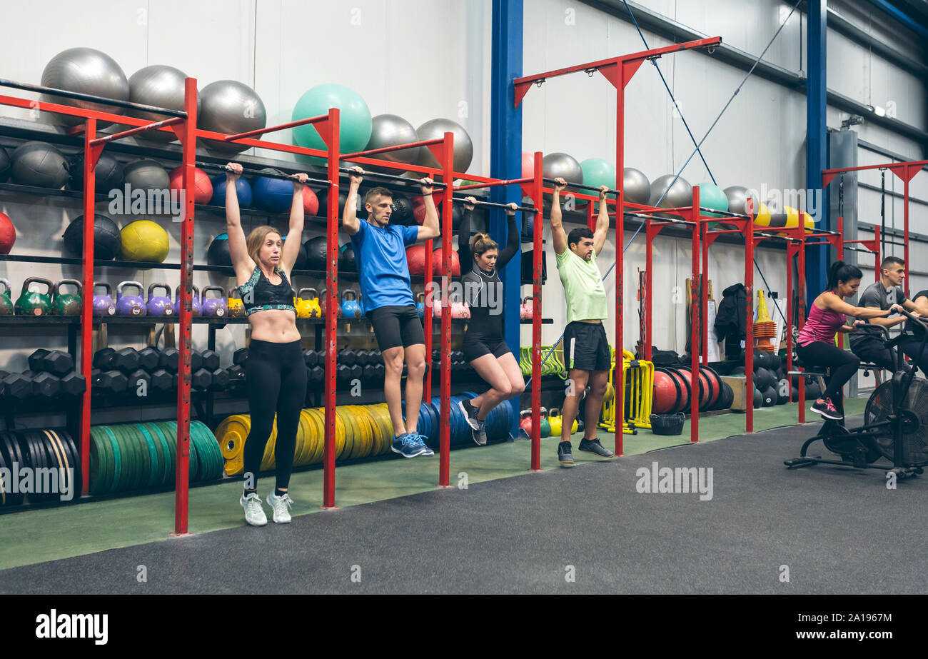 Athletes doing pull ups in the gym Stock Photo