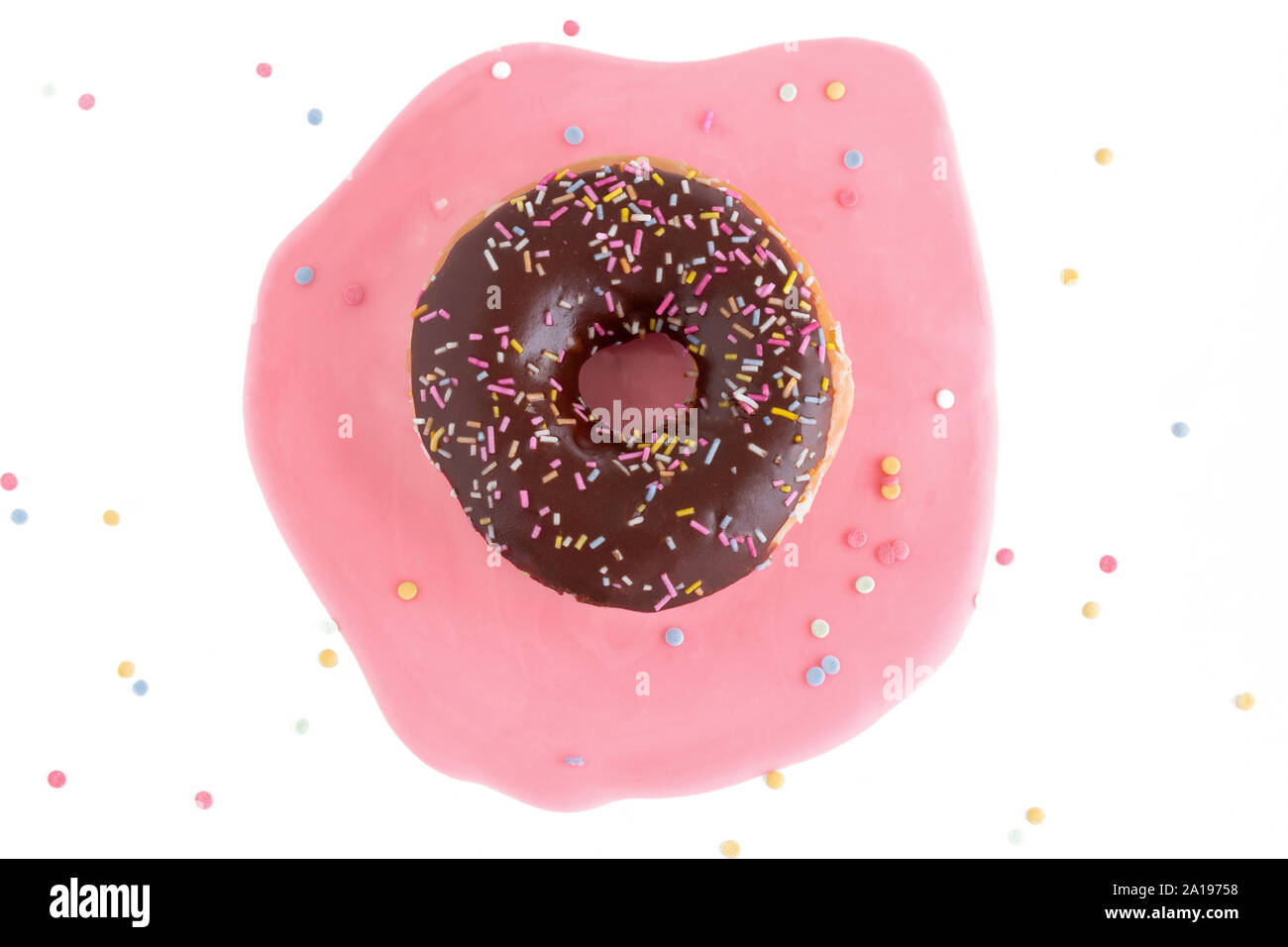 Top view, flat on a donut with chocolate coating and colorful sprinkles. Pink icing stain. Stock Photo