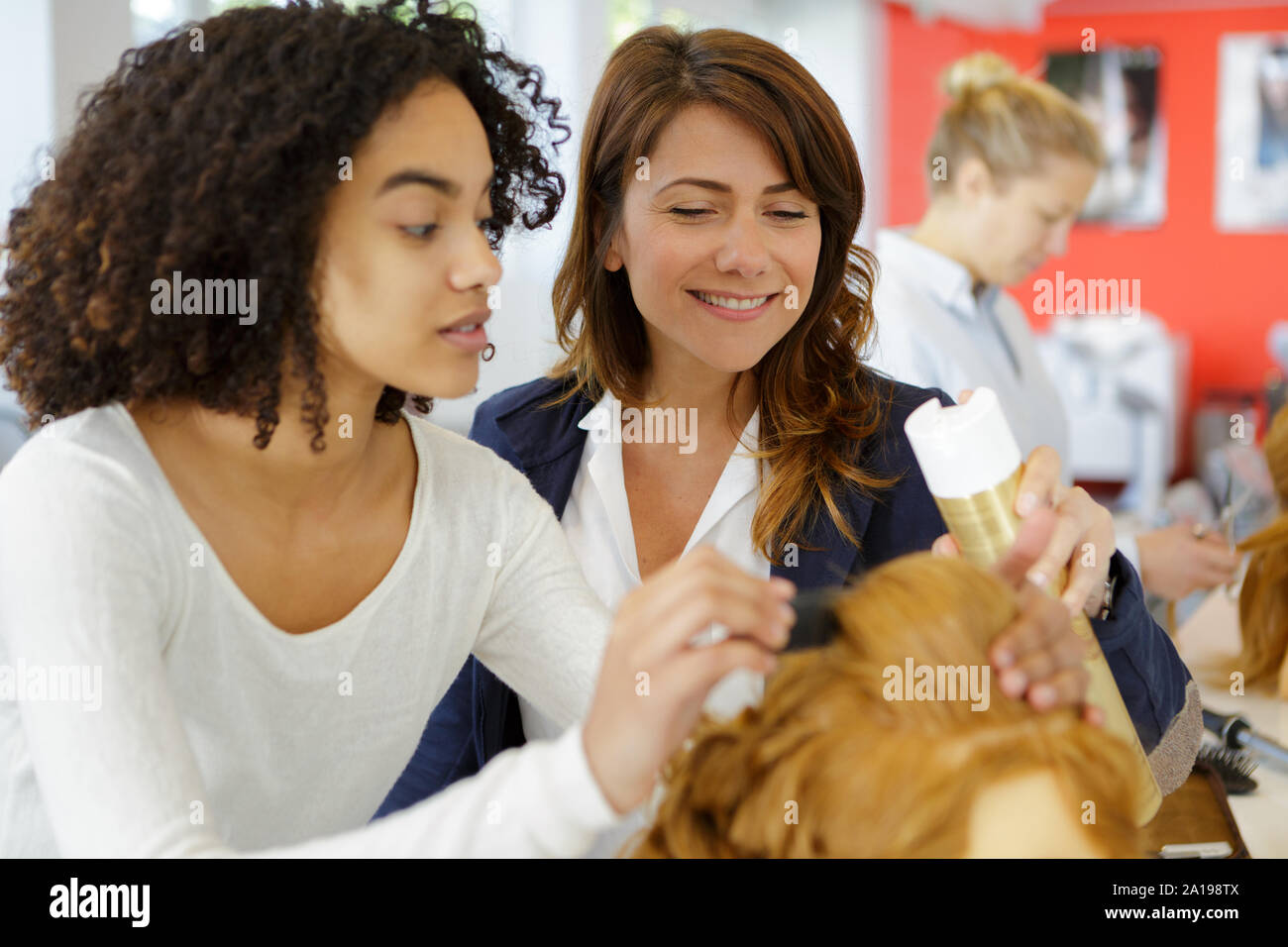 Portrait Of Hairstylist Supervising An Apprentice Stock Photo