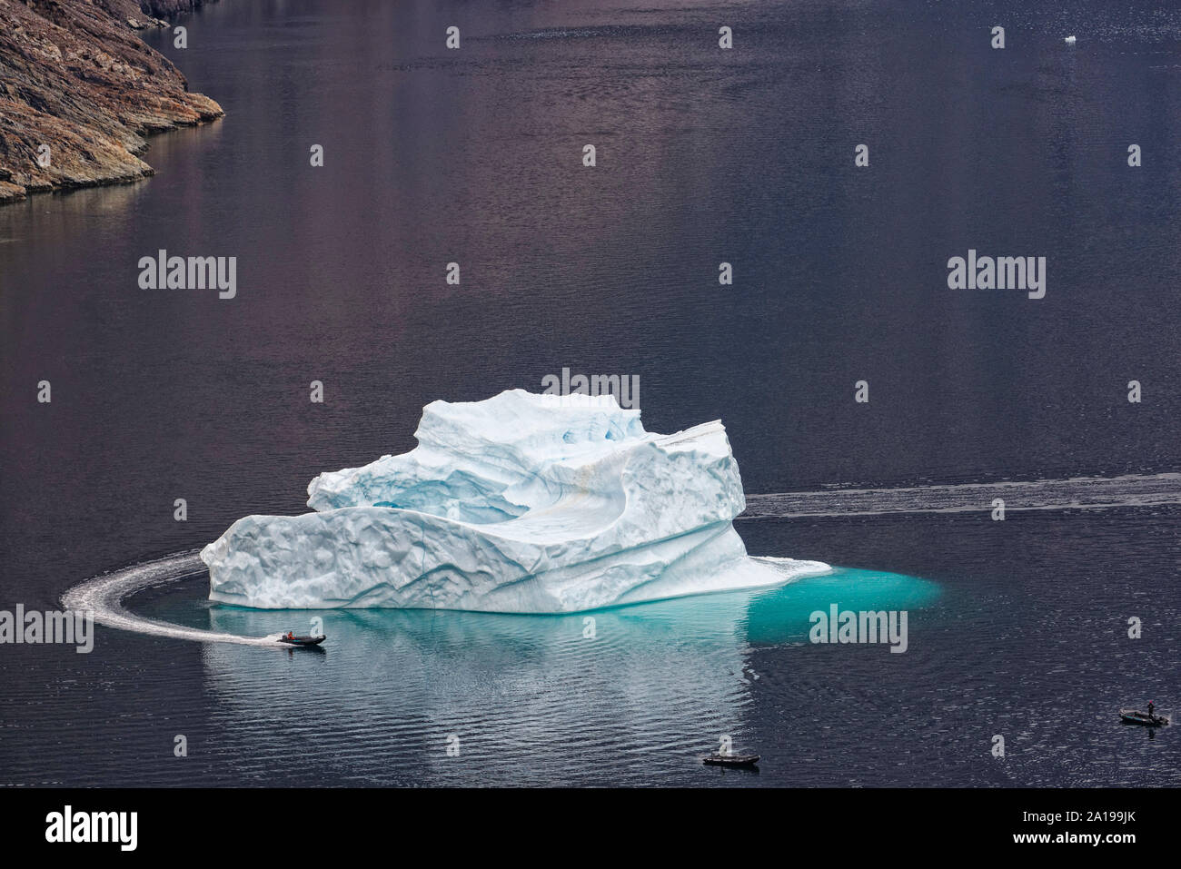 Zodiac umfährt Eisberg, Blomsterbukta, Nordost-Grönland-Nationalpark. Floating iceberg with zodiacs in Blomsterbukta, Kangertittivaq, Greenland, Denma Stock Photo