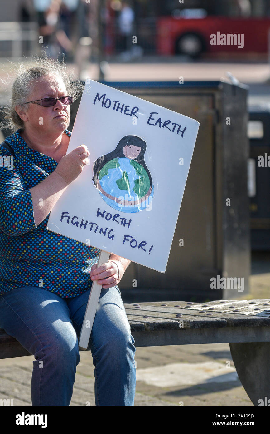 A mature woman holding a placard and participating in the Extinction Rebellion climate strike in Truro City City in Cornwall. Stock Photo
