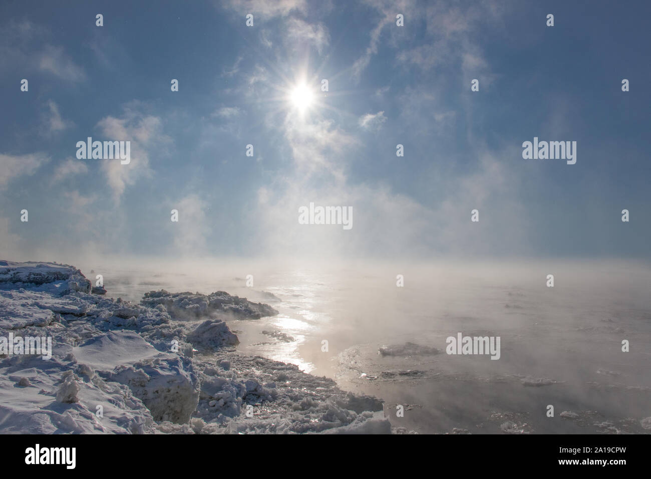 Vapor trails over water on a freezing cold sunny day Stock Photo